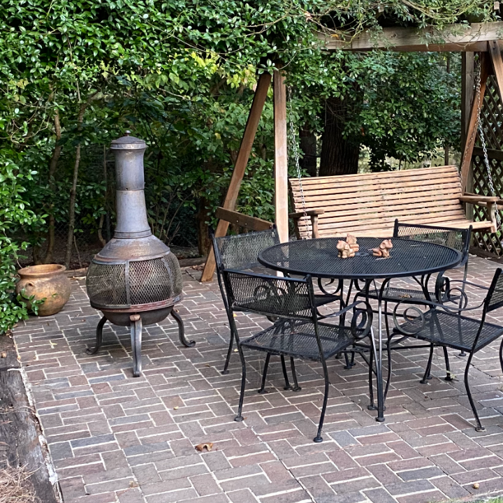 patio with a black metal table and a swing