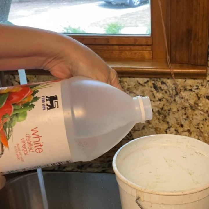 hand pouring vinegar into a container