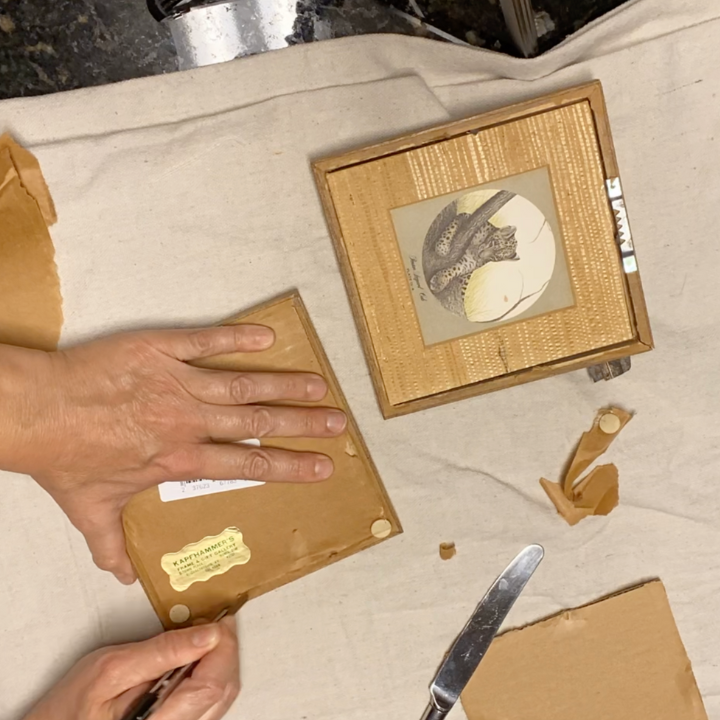 woman taking apart a picture frame