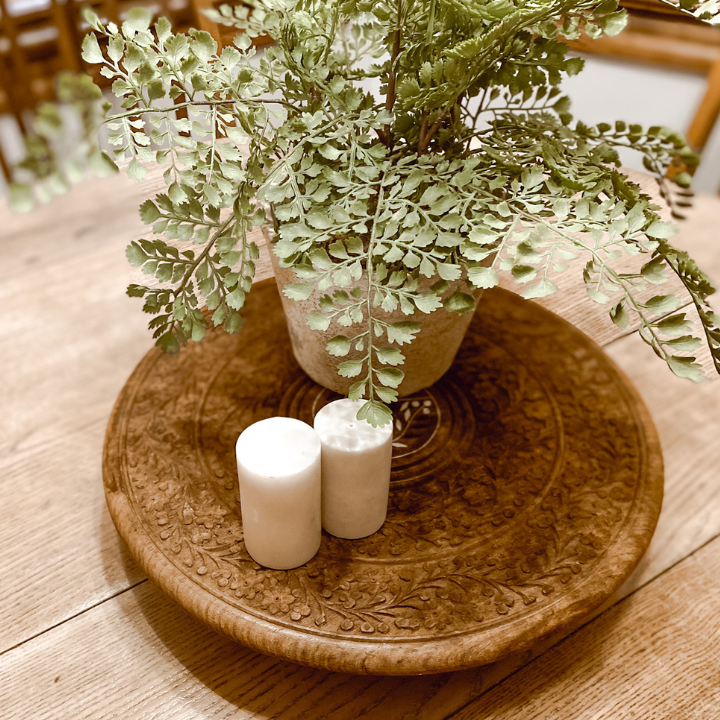 lazy Susan with a green plant and marble salt and pepper shakers on a table