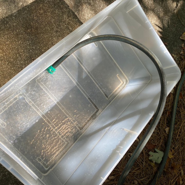 Rubbermaid tote with hose filling with water