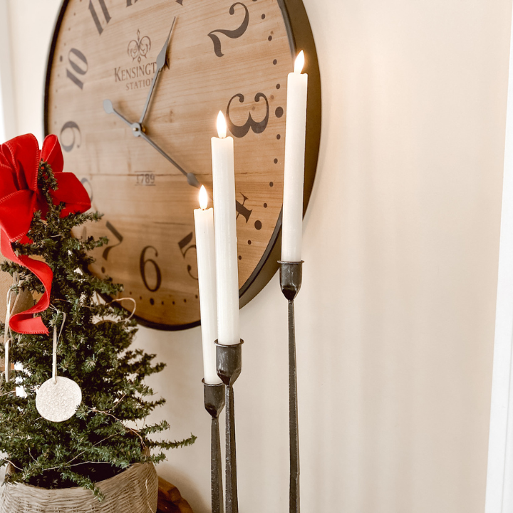flameless candles, black candlesticks, a clock and christmas tree